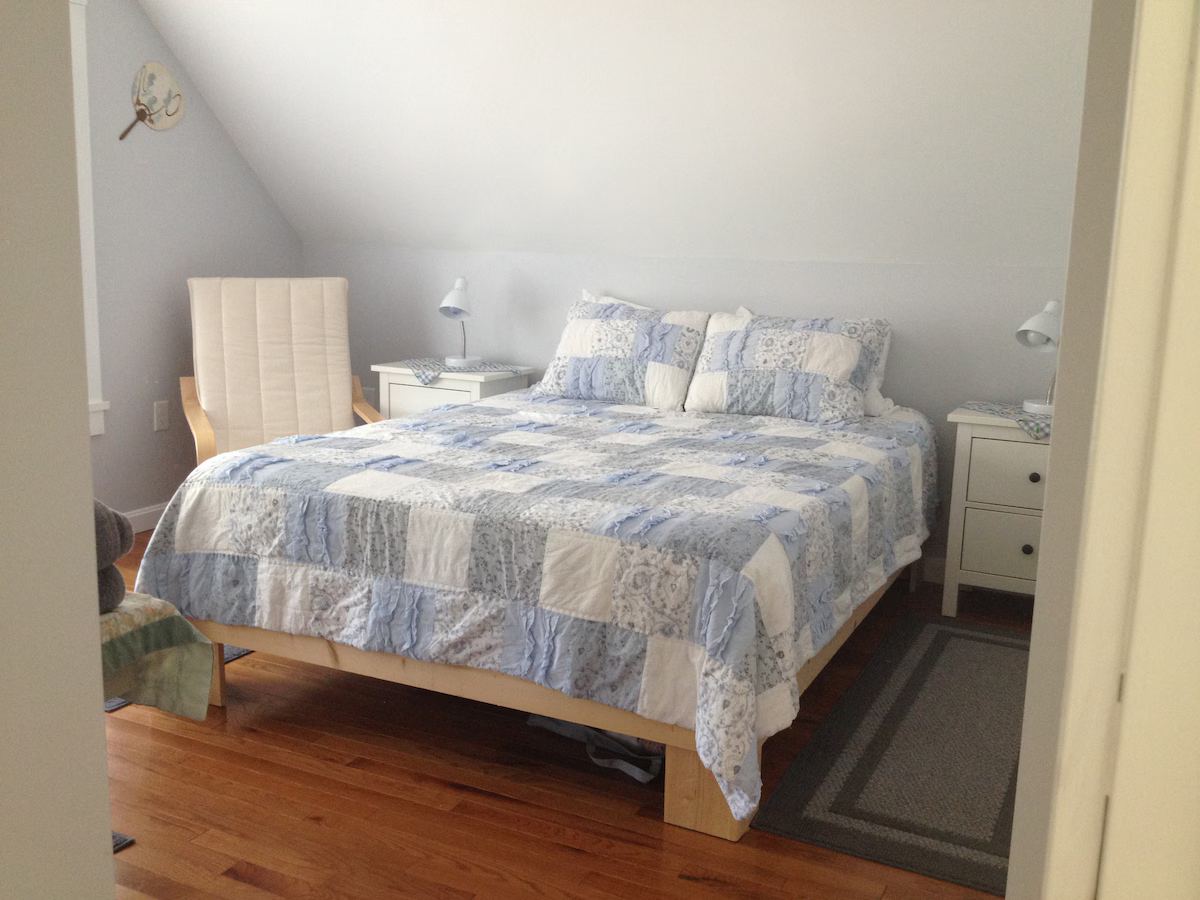 The master bedroom has a queen bed, enough room to practice violin, a comfy chair and plenty of storage and wall hooks. And an ensuite bathroom. at Horror Hill Cottage in Lubec