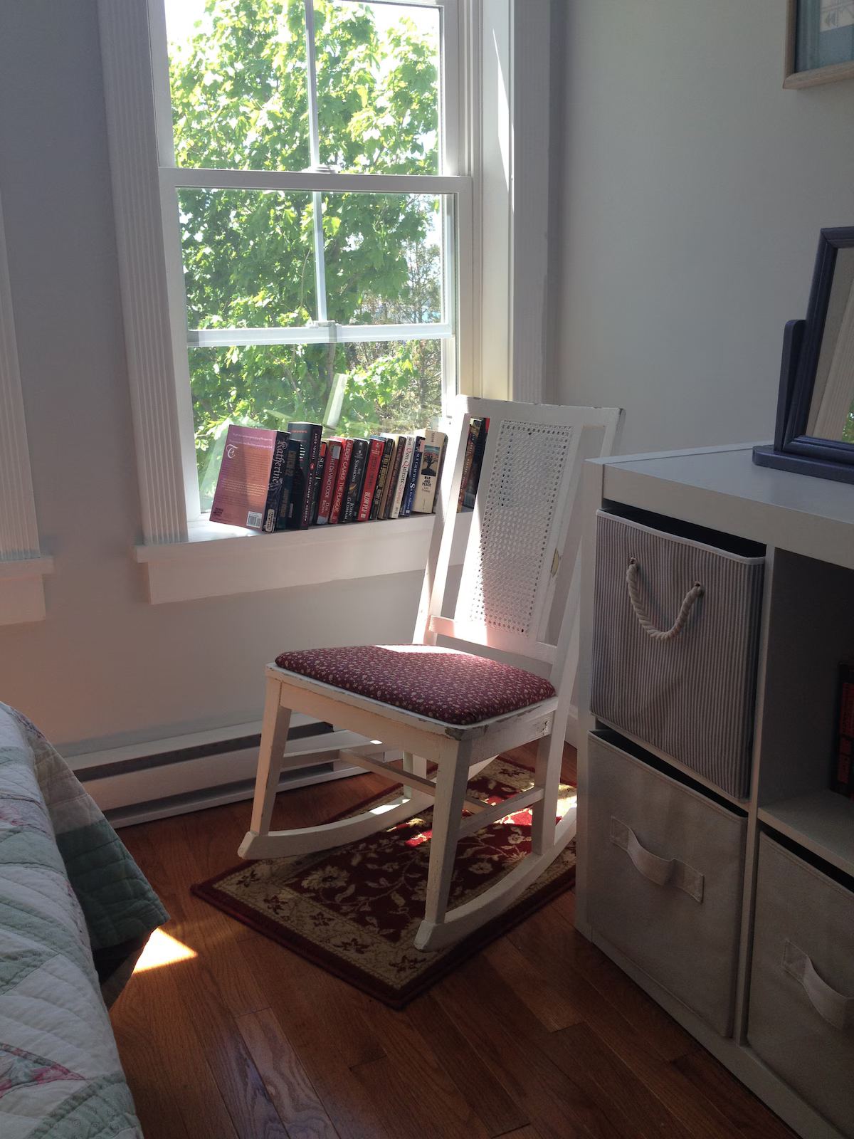 The smaller bedroom is a restful nook with its own bookshelf, plenty of storage and an antique rocker. at Horror Hill Cottage in Lubec
