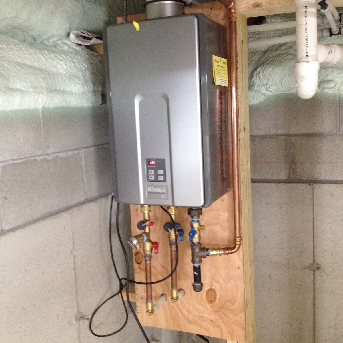 The new Rinnai tankless water heater gives 8.5 gallons a minute of piping hot water - indefinitely. That's the foamed in insulation at top left. at Horror Hill Cottage in Lubec