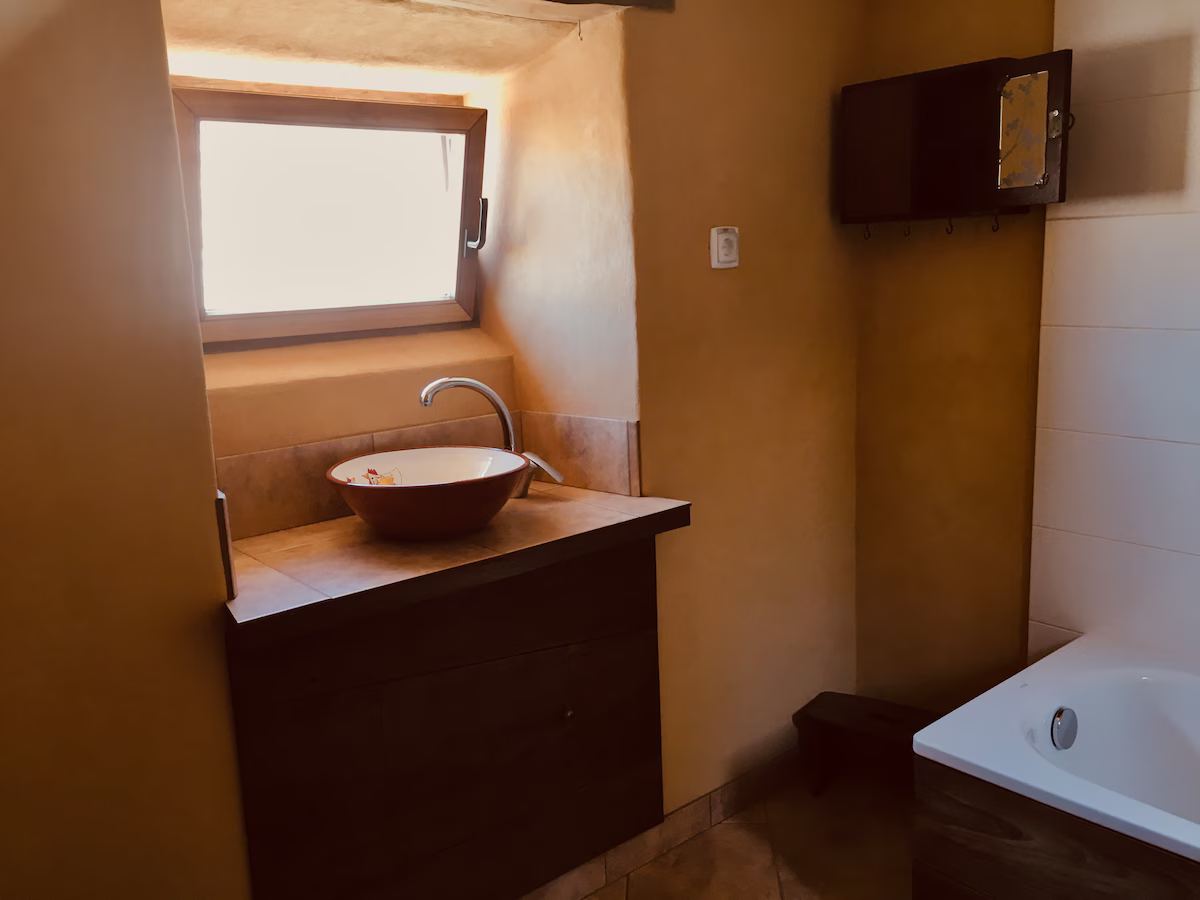 Bathroom with shower over bath, handmade basin and WC. at Quinta Tranquila in Odeceixe
